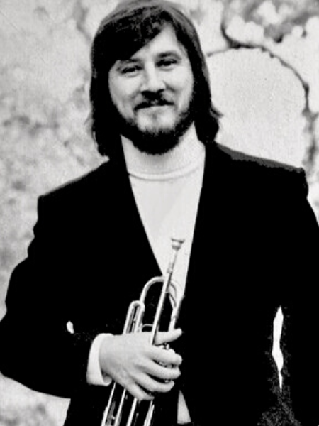 Musician Bill Phillips holding a trumpet.